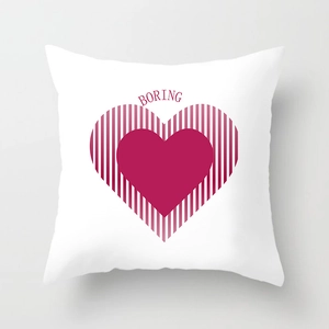 Detail of white square pillowcase with red striped heart design and boring text print
