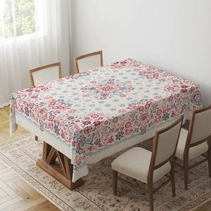 Bohemian floral pattern tablecloth draped over a wooden dining table in a cozy home setting