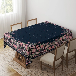 Detail of bohemian rectangle tablecloth with blue floral pattern on a wooden dining table