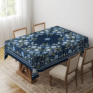 Detail of blue floral tablecloth with vintage bohemian patterns on long wooden dining table
