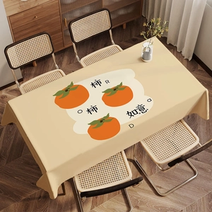 Detail of warm beige tablecloth featuring orange persimmons and Chinese lucky text calligraphy