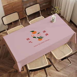 Detailed view of pink rectangular tablecloth featuring peach prints and cursive text