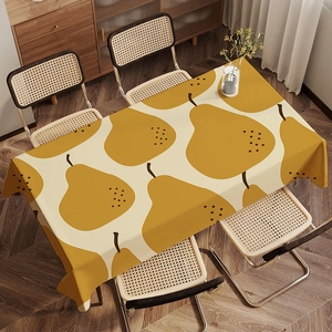 Detailed view of cream rectangular tablecloth with yellow pear print on a dining table