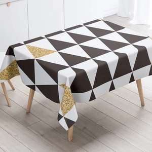 Detail of Nordic tablecloth with black, white and gold geometric triangle patterns