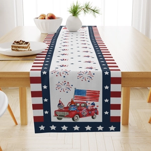 Close-up of July 4th linen table runner with red truck and gnome pattern on wood