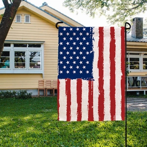 Double-sided burlap garden flag with distressed US flag design in a sunny backyard setting
