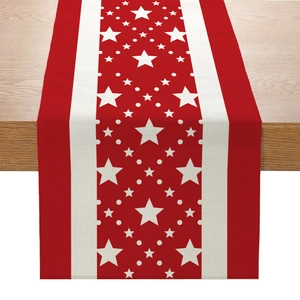 Détail d'un chemin de table en lin avec des étoiles rouges et des pois décoratifs