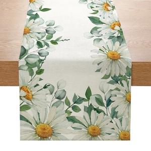 Chemin de table élégant en lin avec feuilles vertes et marguerites sur une table en bois