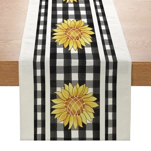 Close-up of linen table runner featuring black gingham pattern and vibrant yellow sunflowers