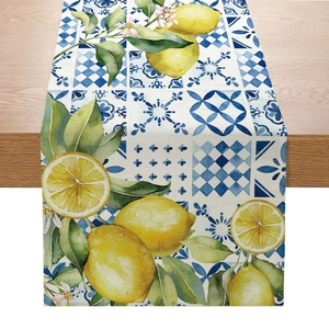 Detail of linen table runner with lemon and Mediterranean blue tile print on wood table