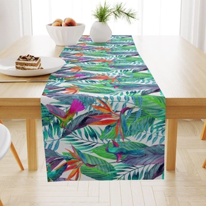 Detailed fabric texture of a tropical table runner with vibrant floral and bird patterns