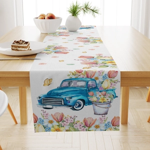 Dettaglio del runner da tavola rustico con stampa di camion blu vintage e fiori freschi
