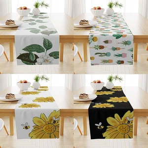 Detail view of linen table runner with four floral prints including sunflowers and cacti