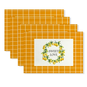 Detail of four-piece cotton linen placemats featuring yellow plaid and lemon print
