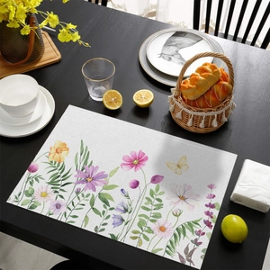 Détail d'un set de table en coton et lin avec fleurs à l'aquarelle et motifs de papillons