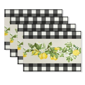 Detail view of four cotton linen placemats with lemon prints and black buffalo plaid patterns
