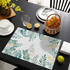 Gros plan du set de table en coton et lin avec motif eucalyptus sur table en bois
