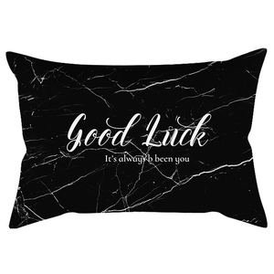 Detail of black marble lumbar pillow cover featuring white cracks and Good Luck text