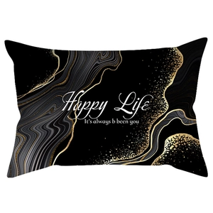 Close-up of black lumbar pillowcase with marble print and Happy Life gold text