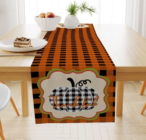 Close-up of fall table runner featuring buffalo plaid pattern and thankful pumpkin print