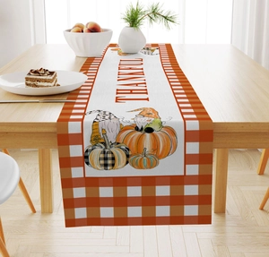 Detail of Thankful linen table runner with autumn gnomes and pumpkins on wooden table