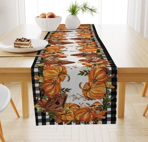 Detailed texture of fall linen table runner with buffalo plaid, pumpkin and maple leaf patterns