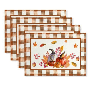 Detail of four waterproof Thanksgiving placemats with pumpkin and maple leaf patterns