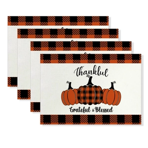 Set of four Thanksgiving placemats featuring pumpkin prints and black orange plaid borders