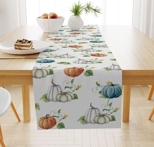 Detailed view of watercolor pumpkin and maple leaf print on linen table runner fabric