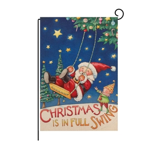 Close-up of linen garden flag with Santa and elf motif on a black metal hanger stand