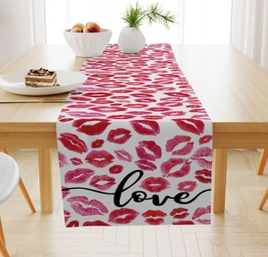 Close-up of linen table runner with red lip prints and love script for Valentine decor