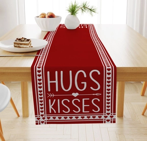 Detail of red Valentine runner with white Hugs Kisses print on a set dining table