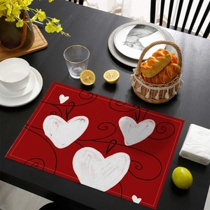 Détail du set de table à motif cœur sur table en bois noir avec accessoires