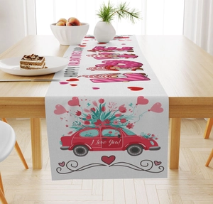 Close-up of Valentine's Day table runner with gnomes and red car on wooden table
