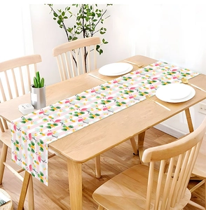 Detail of flamingo and pineapple print on a striped linen table runner for summer