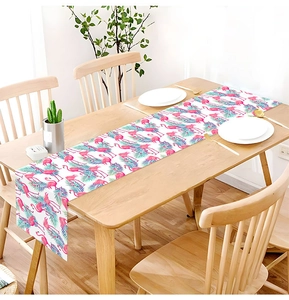 Detailed texture of Hawaiian flamingo floral table runner on a wooden dining table
