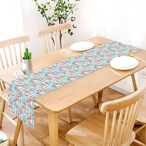 Close-up of linen table runner with pink flamingo prints and blue stripes on a wooden table