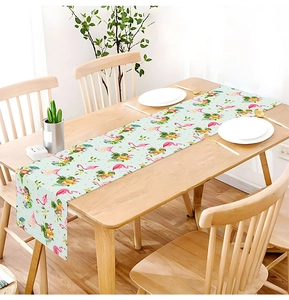 Close-up of tropical flamingo table runner on a wooden dining table with elegant settings