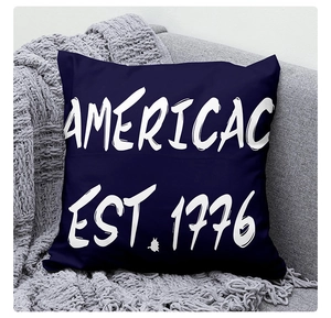 Close-up of navy blue linen pillow cover with AMERICAC 1776 print on a sofa