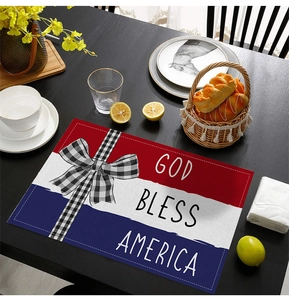 Macro view of Independence Day placemat with God Bless America text on black wood table