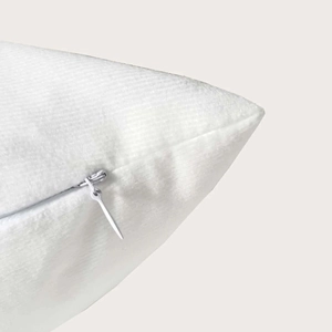 Detail shot of invisible zipper closure on soft plush white checkered throw pillow cover