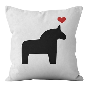 Close-up of a white cushion cover with a minimalist black horse and a red heart detail