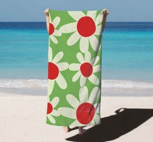 Detail of microfiber beach towel showing vibrant green fabric and white floral pattern