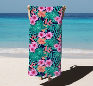 Detail of microfiber beach towel featuring vibrant tropical hibiscus and palm leaf prints