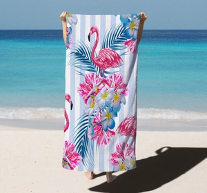 Detail of microfiber beach towel featuring pink flamingo and tropical floral patterns