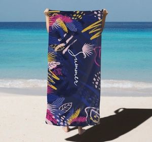 Detail of microfiber beach towel featuring blue tropical leaf prints and Summer text