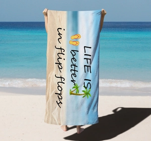 Detail of microfiber beach towel featuring tropical prints and Life is better text