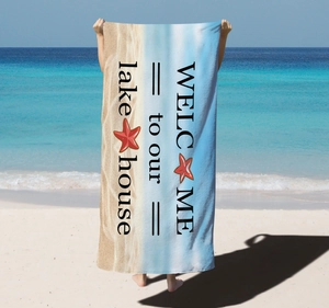 Microfiber beach towel with Lake House print held by a model on a sunny tropical coast