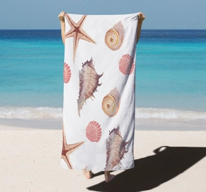 Detailed close-up of quick-dry microfiber beach towel with starfish and seashell patterns