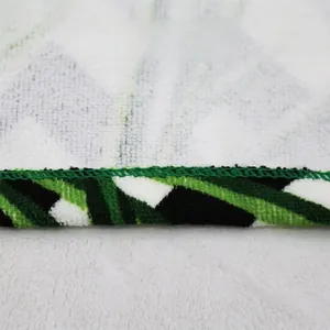 Close-up detail of reinforced stitched edges on microfiber beach towel with geometric patterns